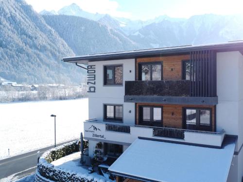 a house with snow on the ground next to a mountain at Spacious Apartment near Ski Area in Mayrhofen in Mayrhofen