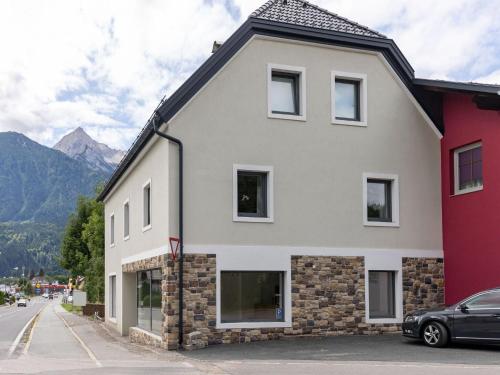 un grand bâtiment blanc avec un toit noir dans l'établissement Gailtaler apartment at an excursion location, à Kötschach-Mauthen