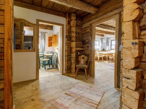 sala de estar con paredes de madera y suelo de madera en Almdorf Hochlienz Apartment Alm 30, en Obernussdorf
