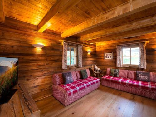 una sala de estar con 2 sofás en una cabaña de madera en Chalet Steinbock St Martin am Tennengebirge, en Sankt Martin am Tennengebirge