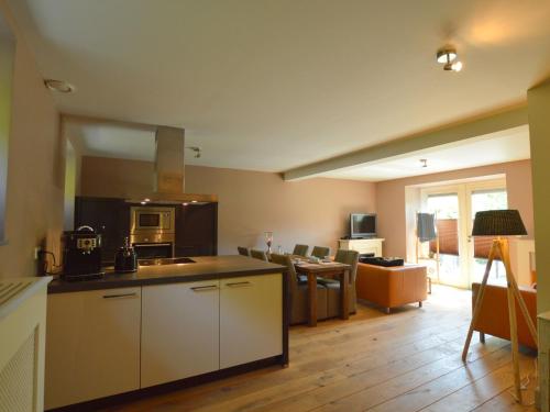 een keuken en een woonkamer met een bank en een tafel bij Stunning Holiday Home near Forest in Slenaken in Slenaken
