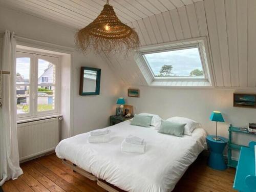 1 dormitorio con 1 cama blanca grande y 2 ventanas en Holiday home, flair&premium comfort near the beach, en Plougasnou
