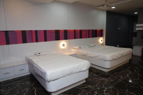 two beds in a hotel room with sidx sidx sidx sidx at Vits Select Grand Inn, Ratnagiri in Ratnagiri