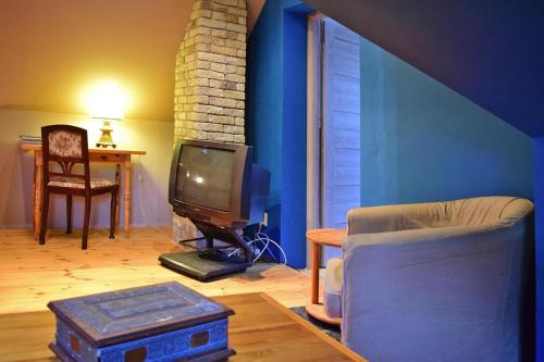 a living room with a couch and a tv at Holiday Home near Lake Dabrowskie in Gołubie