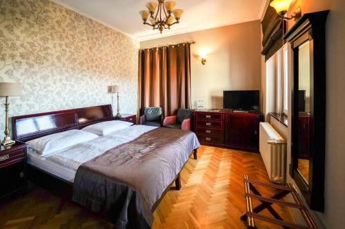 - une chambre avec un grand lit et une télévision dans l'établissement Rezidence Liběchov, à Liběchov