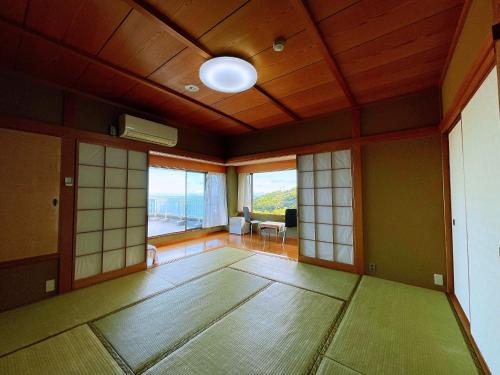 um quarto vazio com um quarto grande com janelas em Izu One Club - Vacation STAY 10141v em Futo