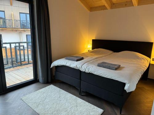 a bedroom with a bed and a large window at Chalet near Nassfeld ski resort in Carinthia in Hermagor