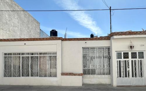 un edificio blanco con puertas de hierro forjado en Casa Madre Santa, en Aguascalientes