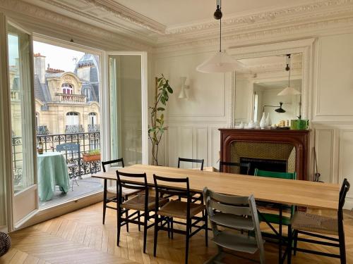une salle à manger avec une table et des chaises et une cheminée dans l'établissement Deluxe Balcony Paris Gare de Lyon, à Paris