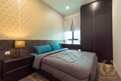 - une chambre avec un grand lit et des oreillers bleus dans l'établissement Princeton Suite @Kuching Airport, à Kuching