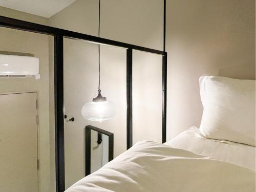 a bedroom with a white bed and a mirror at ST Signature Jalan Besar in Singapore