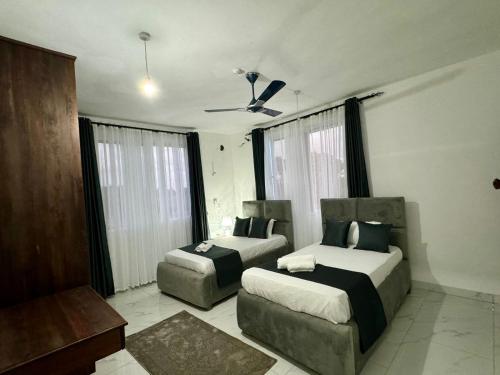 a bedroom with two beds and a couch at Mich Homes in Malindi