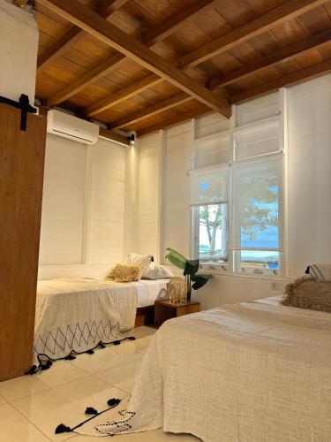 a bedroom with two beds and a window at Villa Tala in Tua Pejat