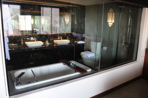 a bathroom with two sinks and a bath tub at Lao Poet Hotel in Vientiane
