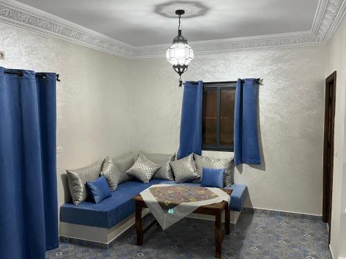 a living room with a blue couch and blue curtains at Dar Tiziri Amizmiz in Marrakech