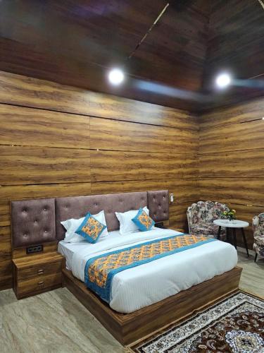 a bedroom with a large bed with wooden walls at wooden suits in Ghaziabad