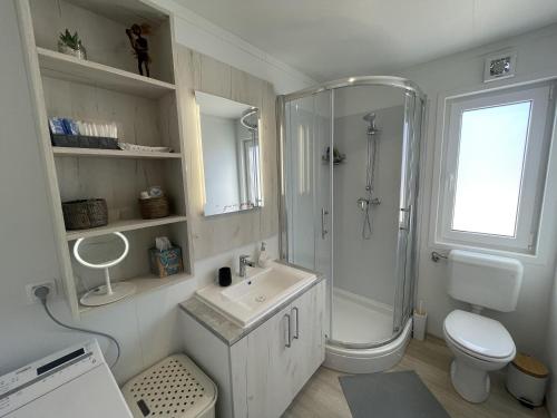 een witte badkamer met een douche en een wastafel bij Arabela Lux Villa in Pakoštane