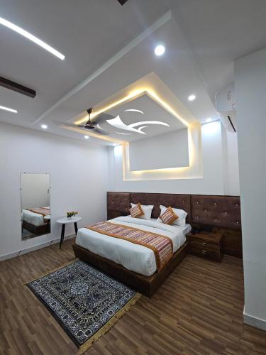 una camera con un grande letto e uno specchio di wooden suits a Ghaziabad