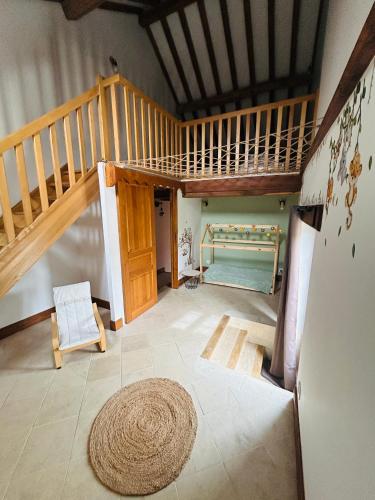 a living room with a staircase and a rug at Gîte La Pause des Anges in Posanges