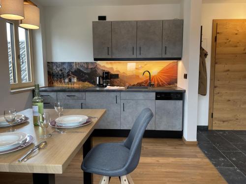 a kitchen with a wooden table with a chair and a dining room at Ferienwohnungen Alpinum in Krün