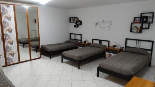 a room with three beds and a mirror at Rose Apartment in Luni