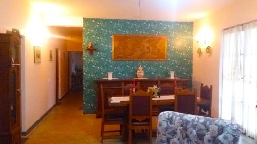 uma sala de jantar com uma mesa e uma parede verde em Villa Como em Maskeliya