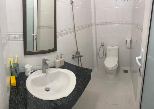 ein weißes Bad mit einem Waschbecken und einem WC in der Unterkunft Khách sạn Tường Minh in Cao Lãnh