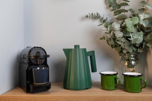 a coffee maker and cups on a wooden shelf at Hôtel Restaurant la Couronne in Chamonix-Mont-Blanc