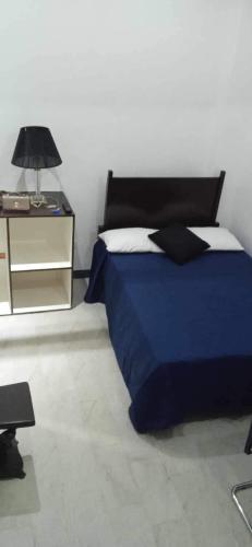 a bedroom with a blue bed and a night stand at Blue-Sky Wave in Antipolo
