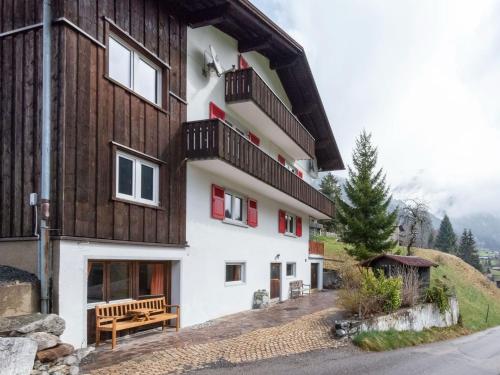 a building with a bench in front of it at Urbane Apartment in Sankt Gallenkirch with Balcony in Sankt Gallenkirch