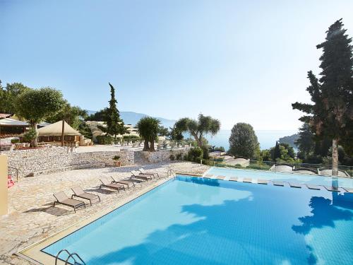 een groot zwembad met ligstoelen in een resort bij Grecotel-LUXME Daphnila Bay Dassia in Dassia