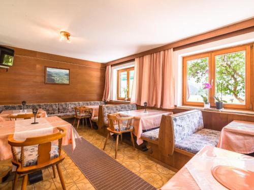 un restaurante con mesas, sofás y ventanas en Contemporary Apartment in Maishofen near Ski Area, en Maishofen