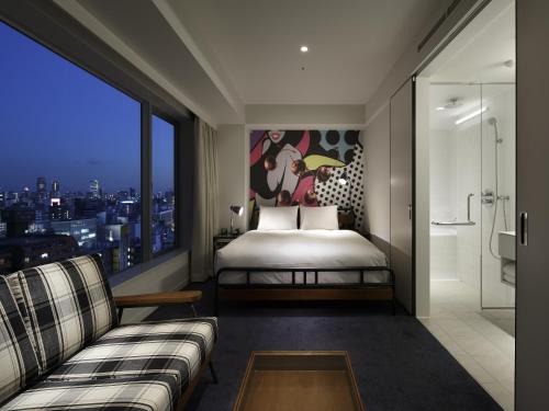 a bedroom with a bed and a large window at Shinjuku Granbell Hotel in Tokyo