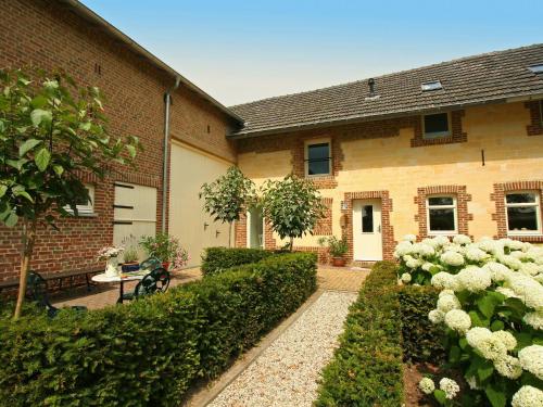 a building with a garden with white roses at Lovely Farmhouse in Wijlre with Forest nearby in Wijlre