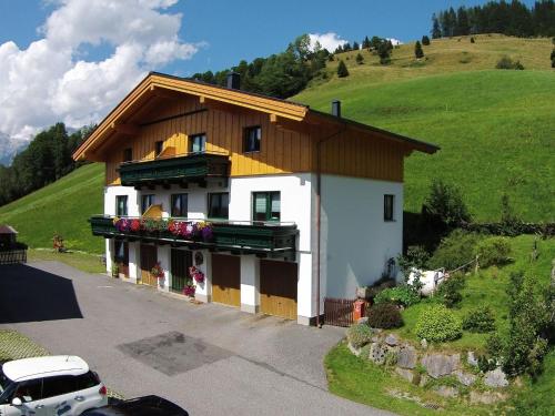 a house on a hill with a car parked in front at Modern Holiday Home in Maria Alm near Ski Area in Maria Alm am Steinernen Meer