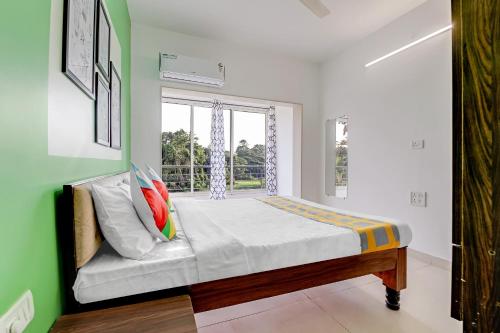Schlafzimmer mit einem Bett und einem Fenster in der Unterkunft OYO Home Hotel Sea Prince Suites in Dona Paula