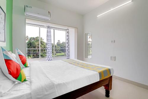 a bedroom with a bed and a window at OYO Home Hotel Sea Prince Suites in Dona Paula