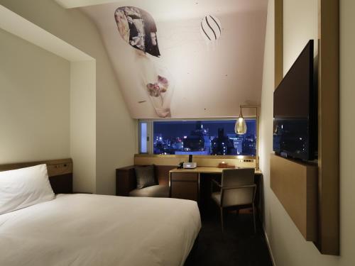a bedroom with a bed and a tv at Shinjuku Granbell Hotel in Tokyo