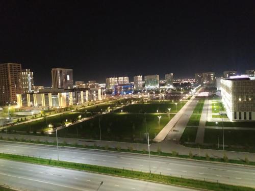 vista di una città di notte con luci di strada di 3 комнатная квартира a Türkistan