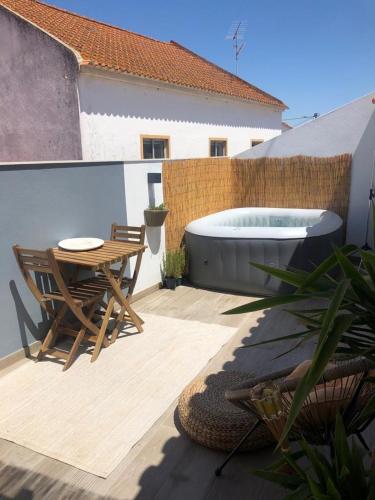 a patio with a table and a bath tub at Casa do Ferreiro by Valada Village in Valada