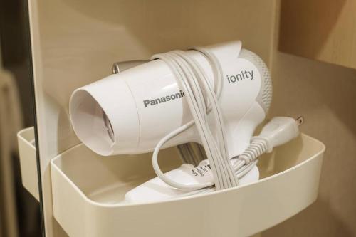 a hair dryer in a white container in a room at Bios Sapporo in Sapporo