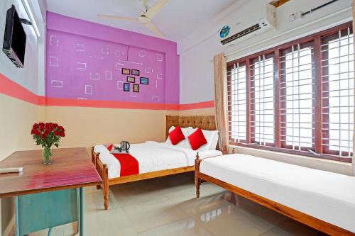 a bedroom with two beds and a window at SPOT ON The New View Regency in Trivandrum