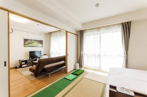 a living room with a couch and a television at Bios Sapporo in Sapporo
