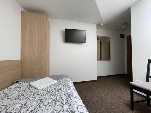 a bedroom with a bed and a tv on the wall at Hotelik Gold in Raszyn