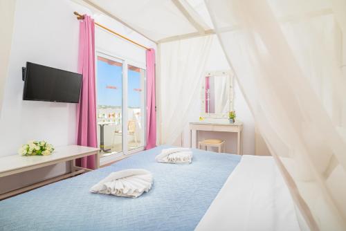 a bedroom with two pillows on a bed with a window at Aris Studios in Hersonissos