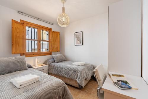 a bedroom with a bed and a desk with a desk at Villa picena las alpujarras in Picena