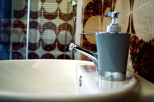 a bathroom sink with a soap dispenser on top of it at Bed and Breakfast da Peppino in Bianchi