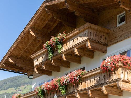 a building with wooden balconies and flowers on it at Upscale Apartment in Salzburg with terrace and country views in Hollersbach im Pinzgau