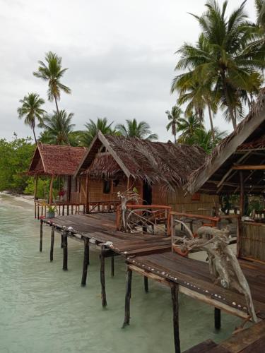 a pier on the water next to a house at Fam Homestay in Fam