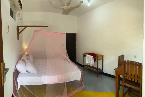 a bedroom with a bed with a mosquito net at Aaliya Bay in Arugam Bay